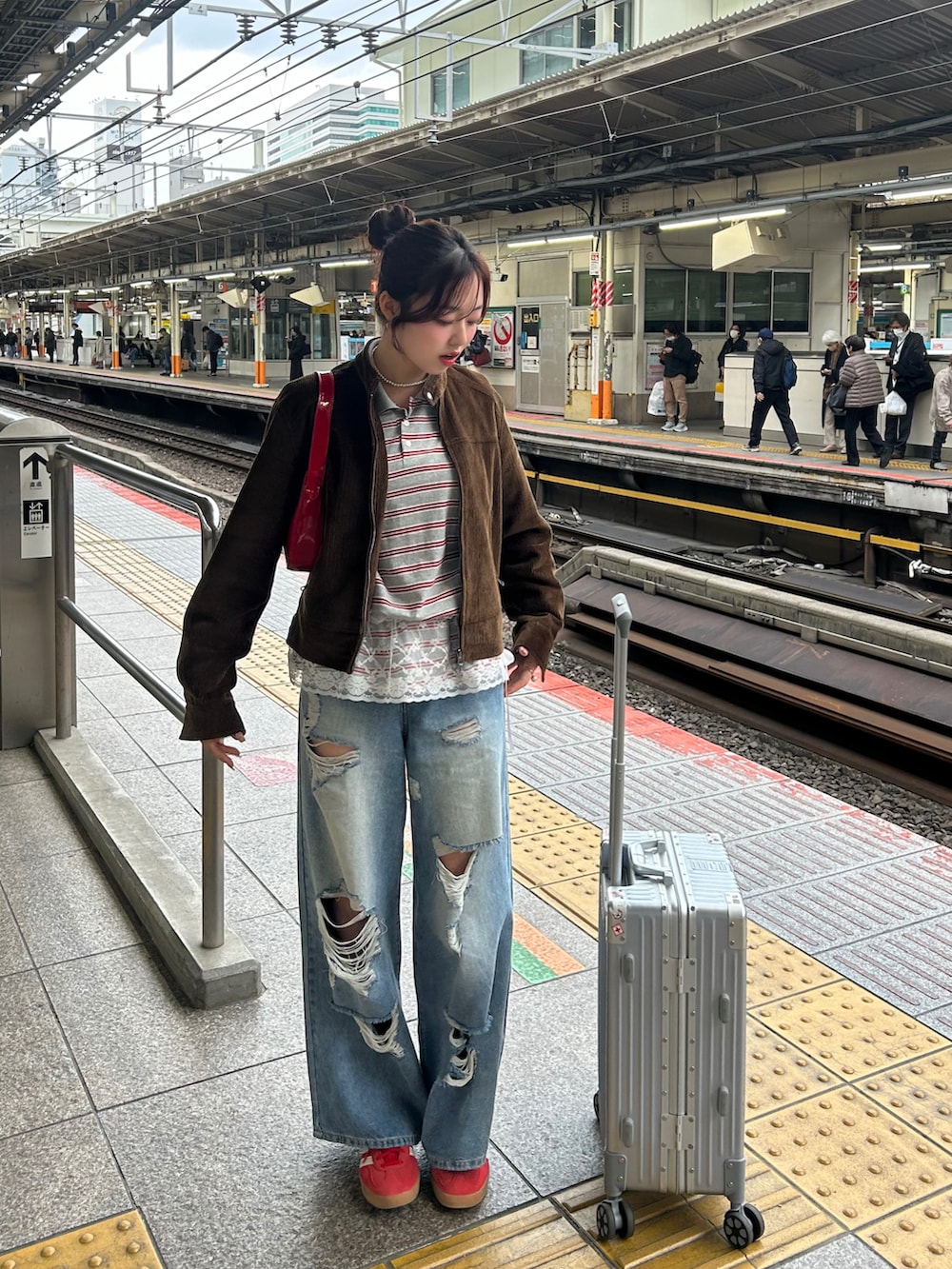 レッド系のスニーカー、ブルー系のデニムパンツ、グレー系のニット/セーターを着用したレディースの春コーディネートの2枚目の写真