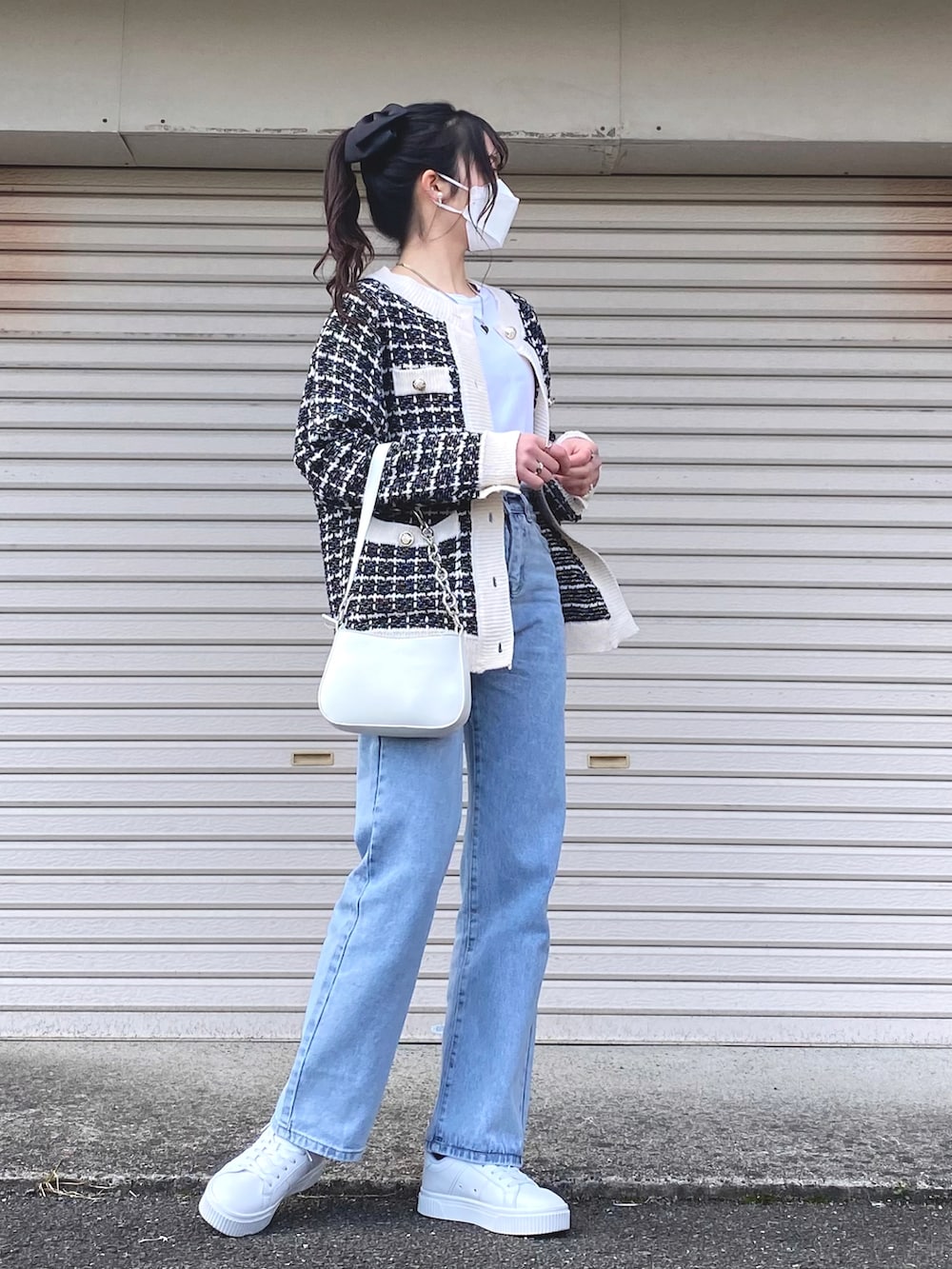 ホワイト系のスニーカー、ホワイト系のショルダーバッグ、ブラック系のカーディガン/ボレロを着用したレディースの春コーディネートの2枚目の写真