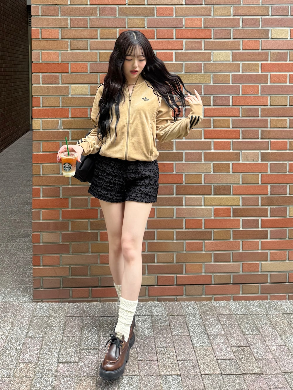 ブラウン系のジャージ、ブラック系のスウェットパンツ、ブラック系のバックパック/リュックを着用したレディースの秋コーディネートの2枚目の写真