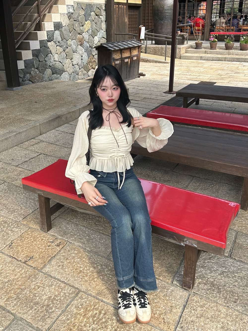 ブラウン系のハンドバッグ、ブルー系のデニムパンツ、イエロー系のTシャツ/カットソーを着用したレディースの春コーディネートの2枚目の写真