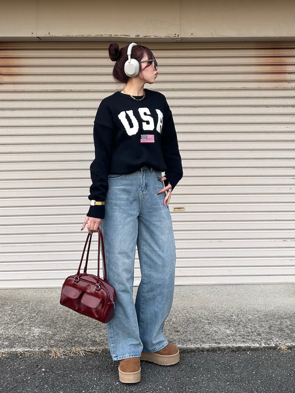 レッド系のハンドバッグ、ブラウン系のブーツを着用したレディースの冬コーディネートの2枚目の写真