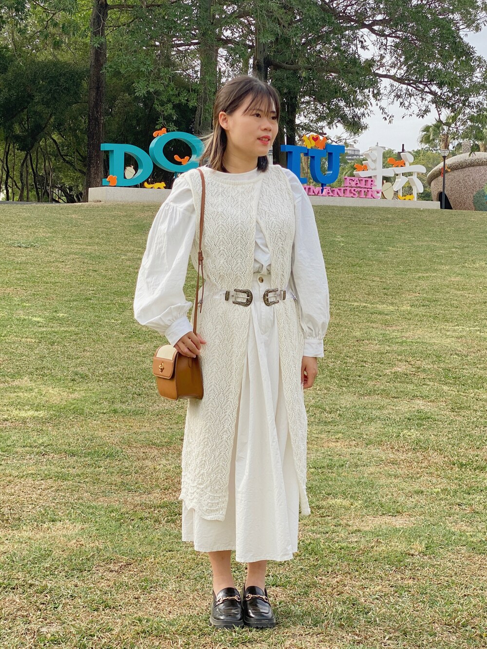 ブラウン系のショルダーバッグ、ブラック系のローファーを着用したレディースの冬コーディネートの3枚目の写真