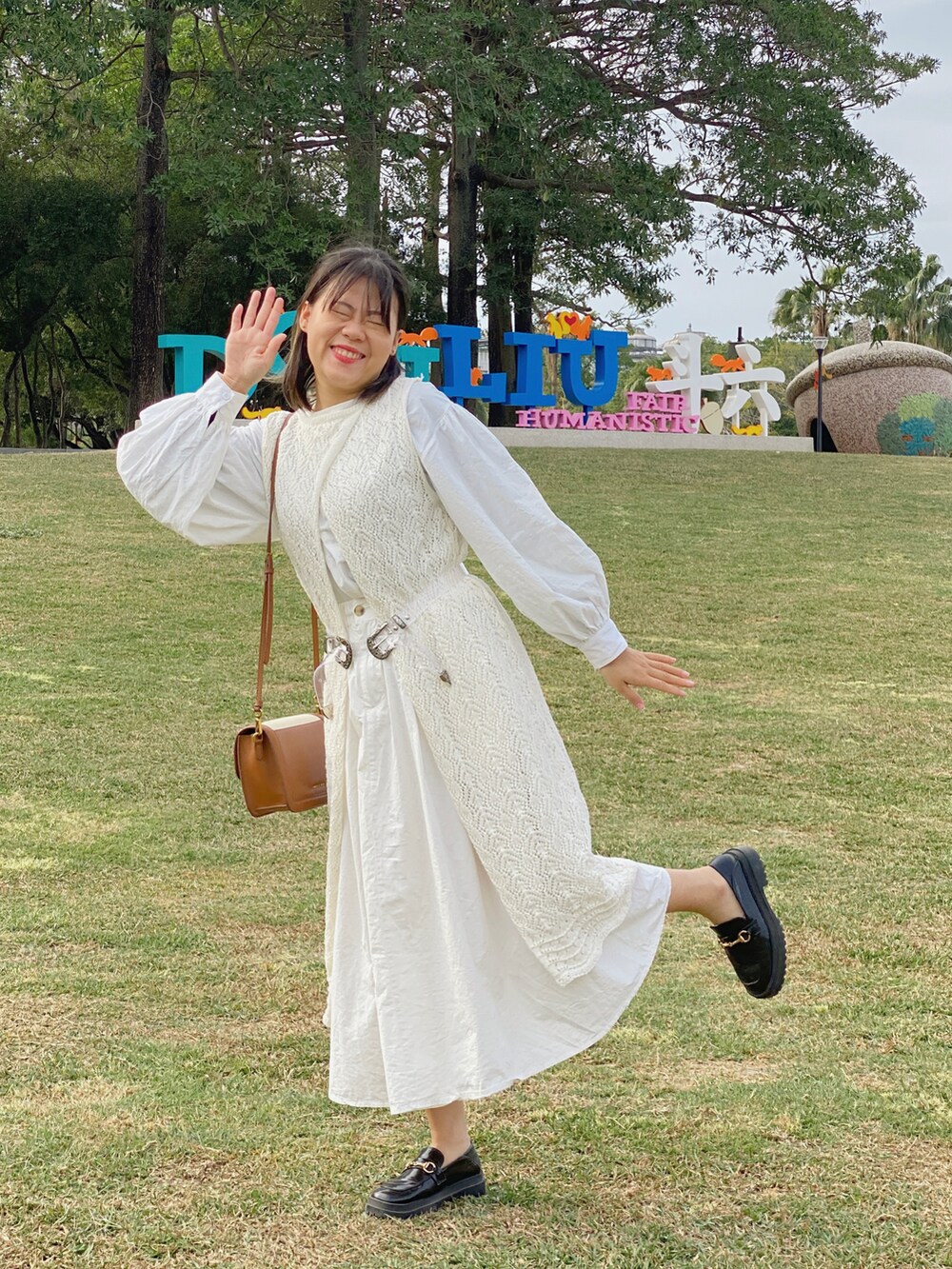 ブラウン系のショルダーバッグ、ブラック系のローファーを着用したレディースの冬コーディネートの4枚目の写真