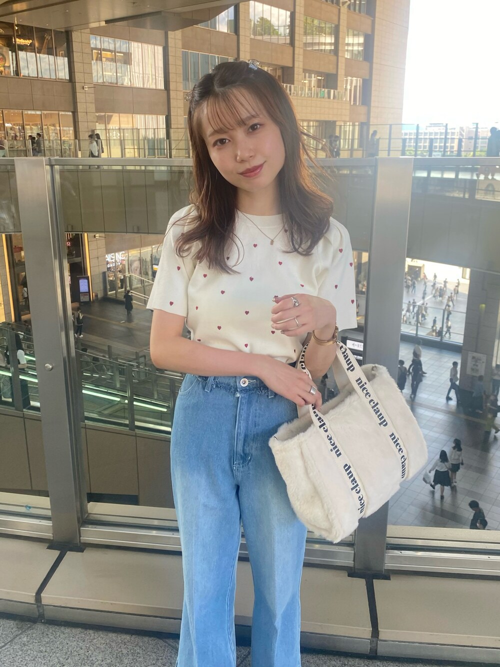 ホワイト系のトートバッグ、レッド系のバレエシューズ、ブルー系のデニムパンツを着用したレディースの夏コーディネートの2枚目の写真