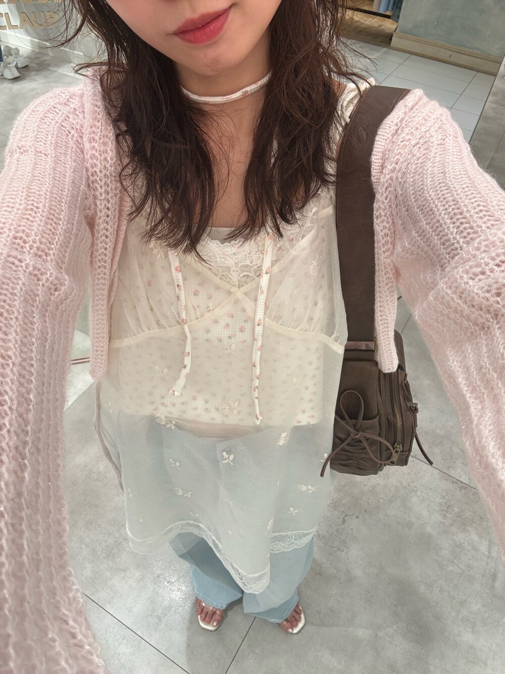 ピンク系のTシャツ/カットソー、ブルー系のデニムパンツ、ホワイト系のチュニックを着用したレディースの夏コーディネートの3枚目の写真