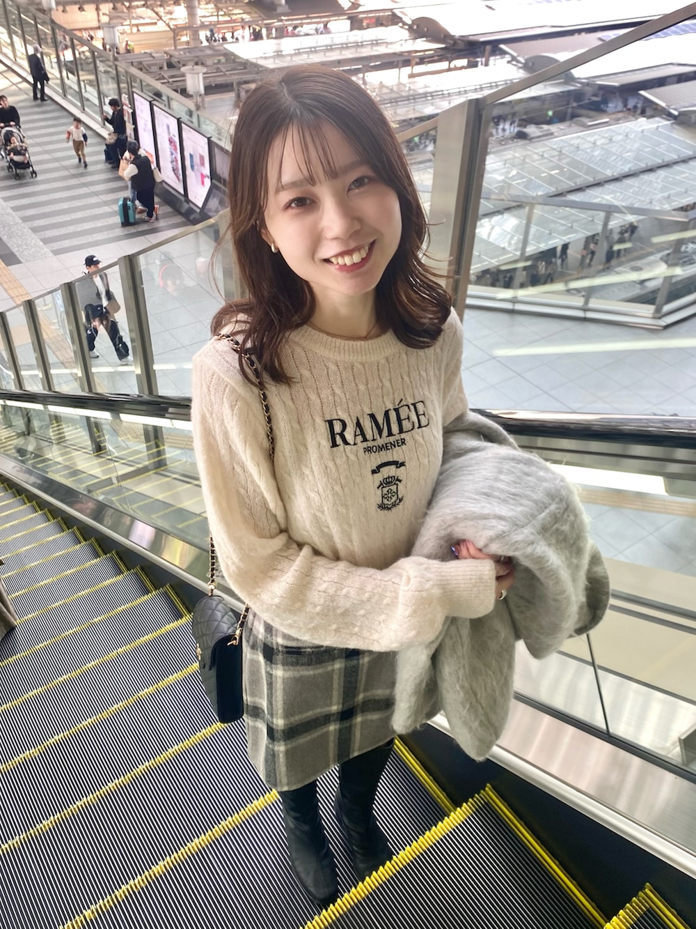ブラック系のブーツ、グレー系のスカート、グレー系のピーコートを着用したレディースの秋コーディネートの3枚目の写真