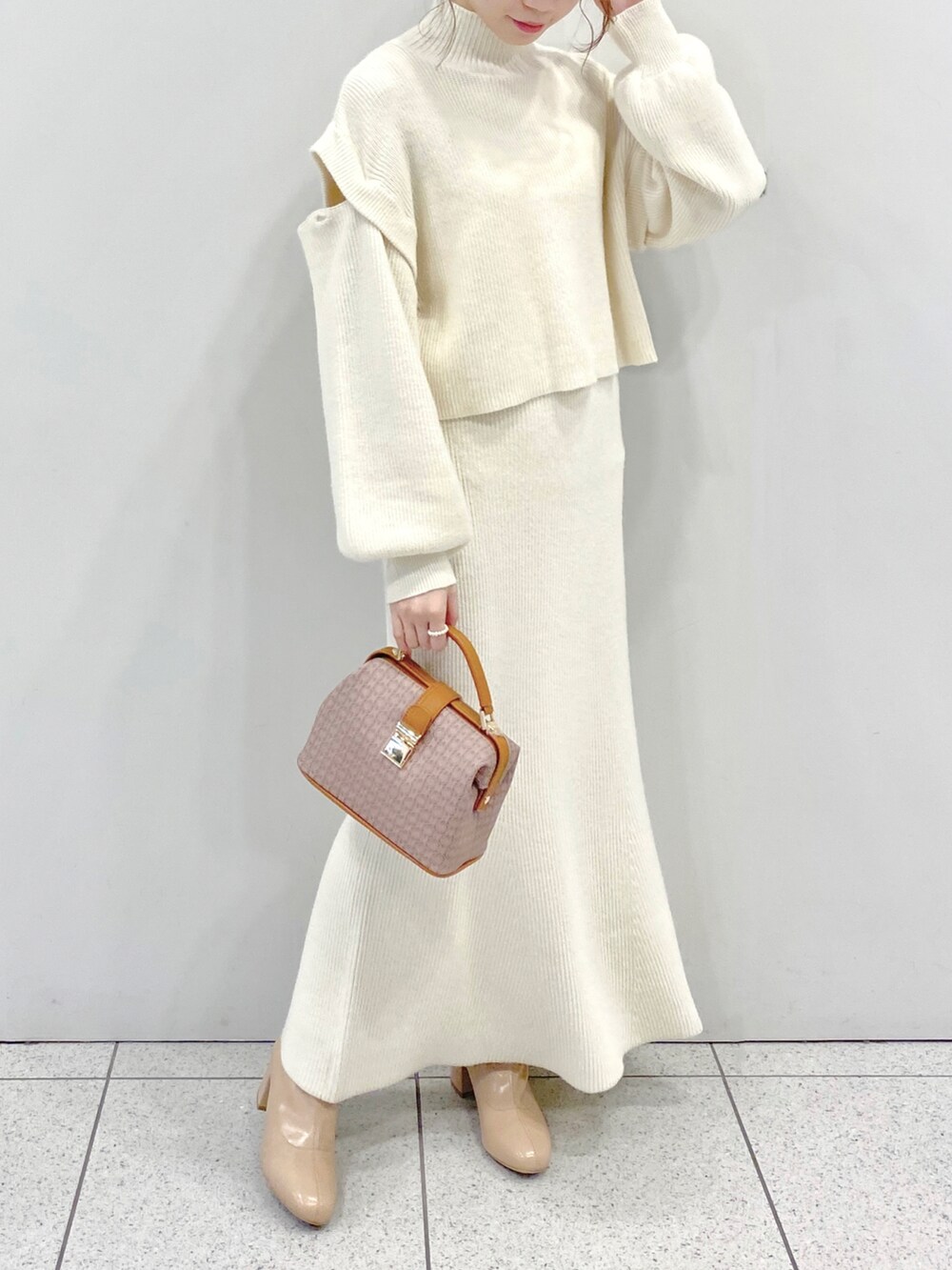 ベージュ系のショルダーバッグ、ベージュ系のブーツ、ホワイト系のワンピースを着用したレディースの秋コーディネートの3枚目の写真