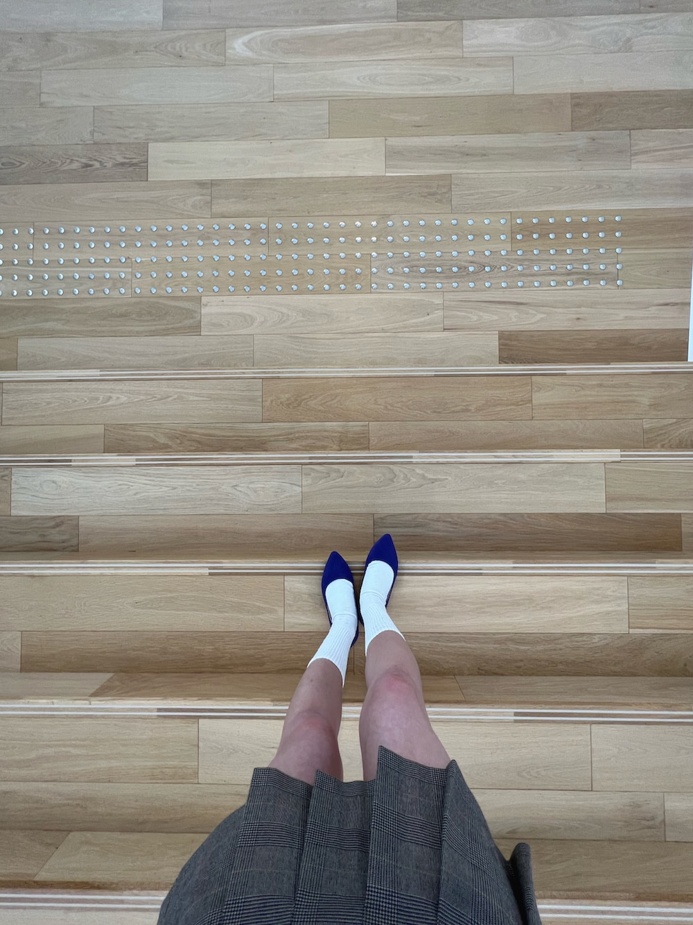 ホワイト系のハンドバッグ、ブラウン系のスーツジャケットを着用したレディースの春コーディネートの3枚目の写真