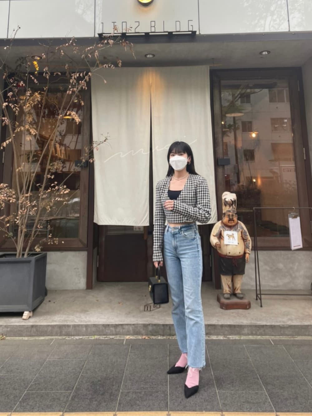 ブラック系のパンプス、ブルー系のデニムパンツ、ブラック系のハンドバッグを着用したレディースの春コーディネートの2枚目の写真