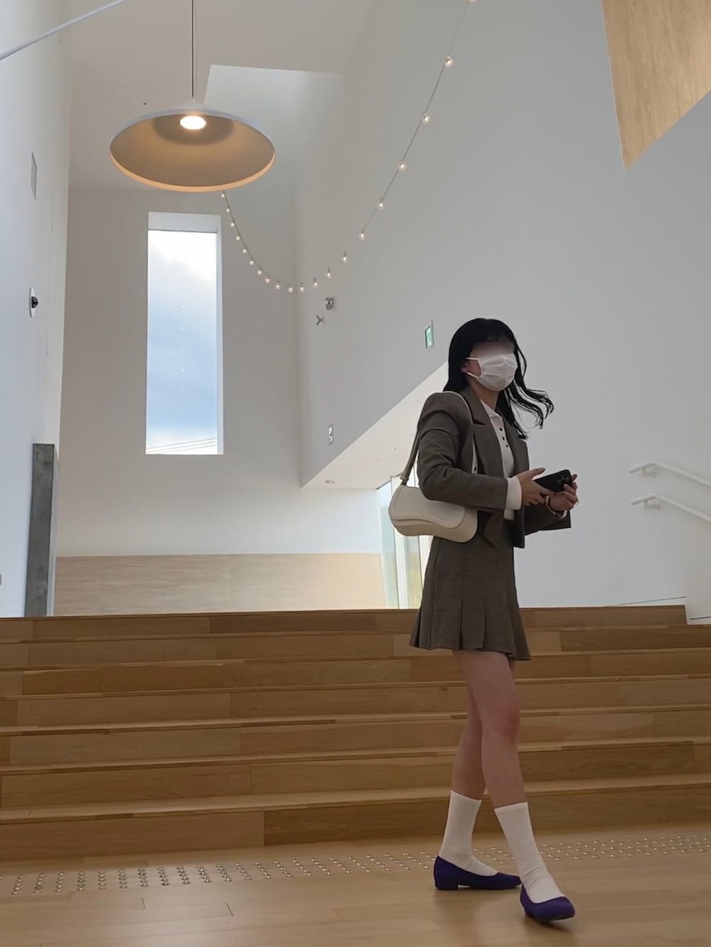 ホワイト系のハンドバッグ、ブラウン系のスーツジャケットを着用したレディースの春コーディネートの2枚目の写真