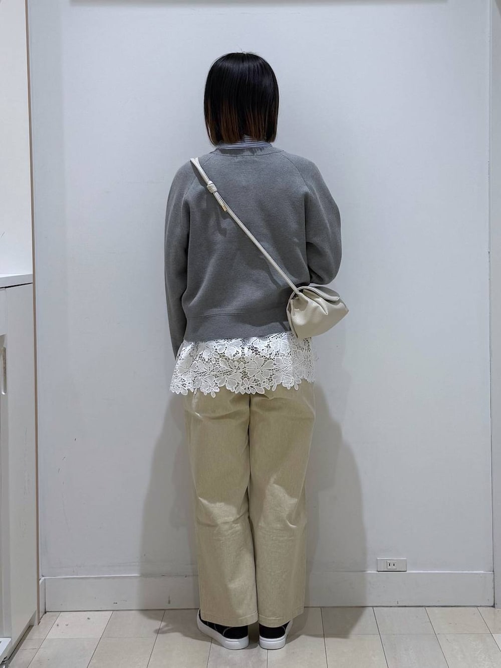 ベージュ系のショルダーバッグ、ベージュ系のデニムパンツ、グレー系のカーディガン/ボレロを着用したレディースの春コーディネートの3枚目の写真