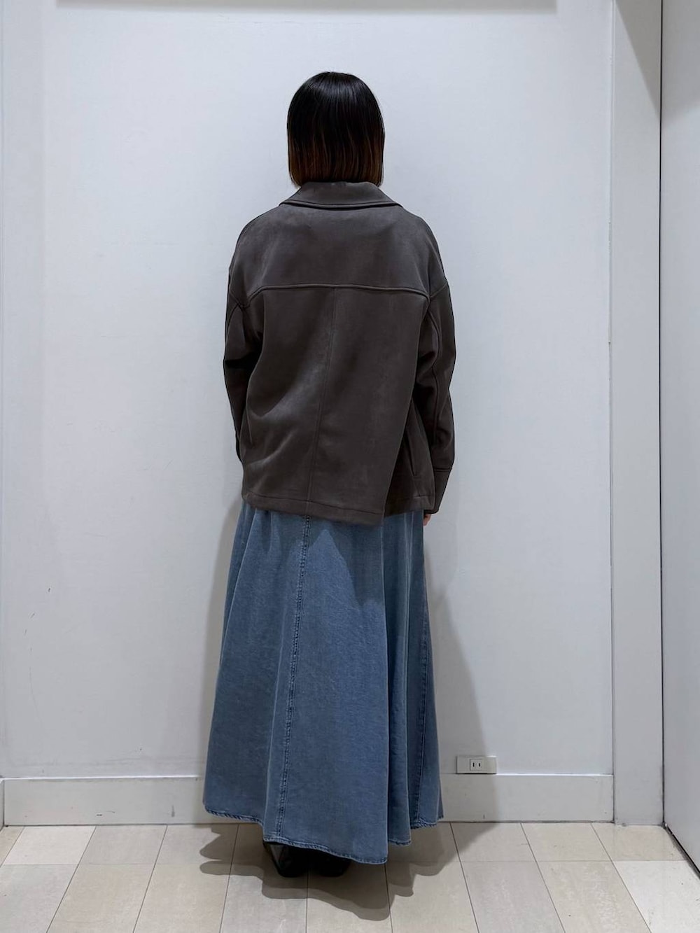 ブラック系のバレエシューズ、ホワイト系のバックパック/リュック、グレー系のテーラードジャケットを着用したレディースの冬コーディネートの3枚目の写真