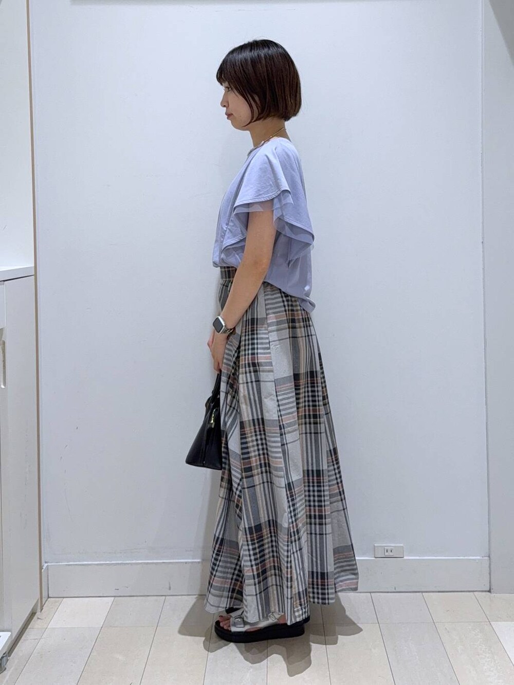 ブラック系のショルダーバッグ、パープル系のTシャツ/カットソー、シルバー系のサンダルを着用したレディースの夏コーディネートの2枚目の写真