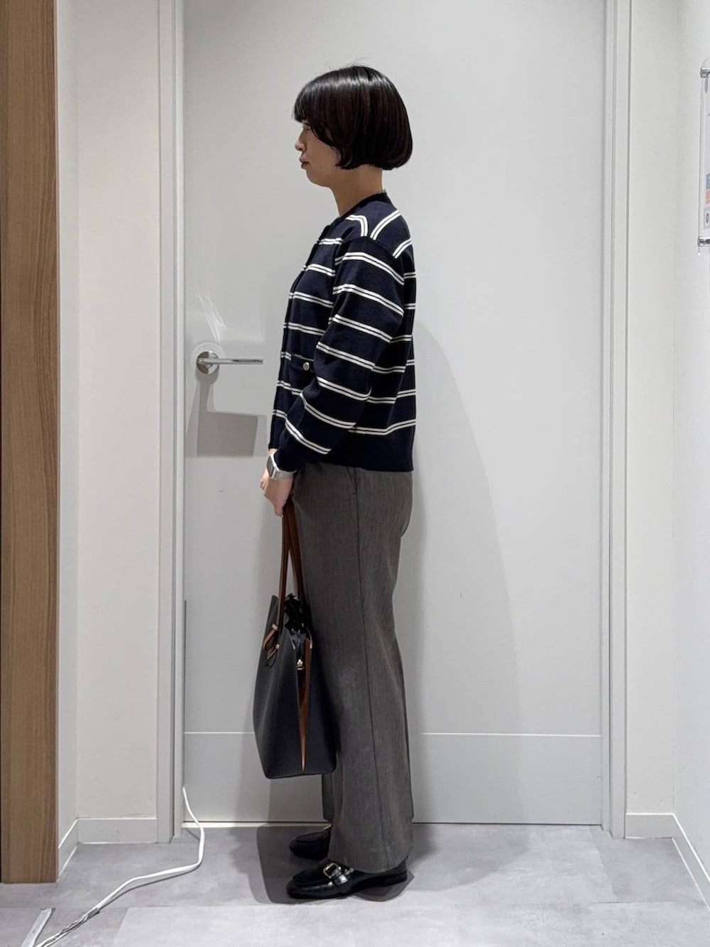 ブラック系のトートバッグ、グレー系のその他パンツ、ブルー系のカーディガン/ボレロを着用したレディースの秋コーディネートの2枚目の写真