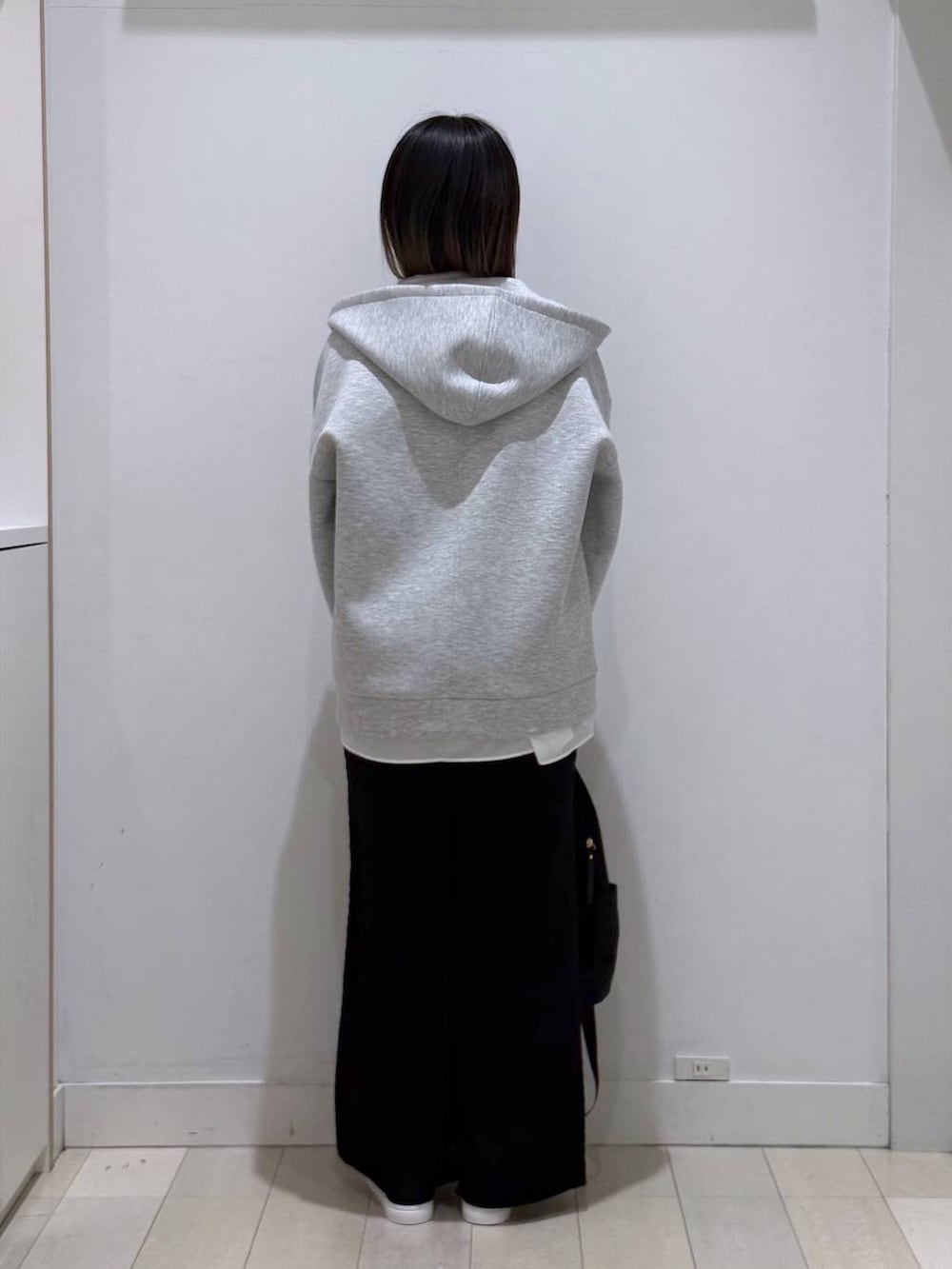 ブラック系のバックパック/リュック、グレー系のパーカー、ホワイト系のタンクトップを着用したレディースの春コーディネートの3枚目の写真