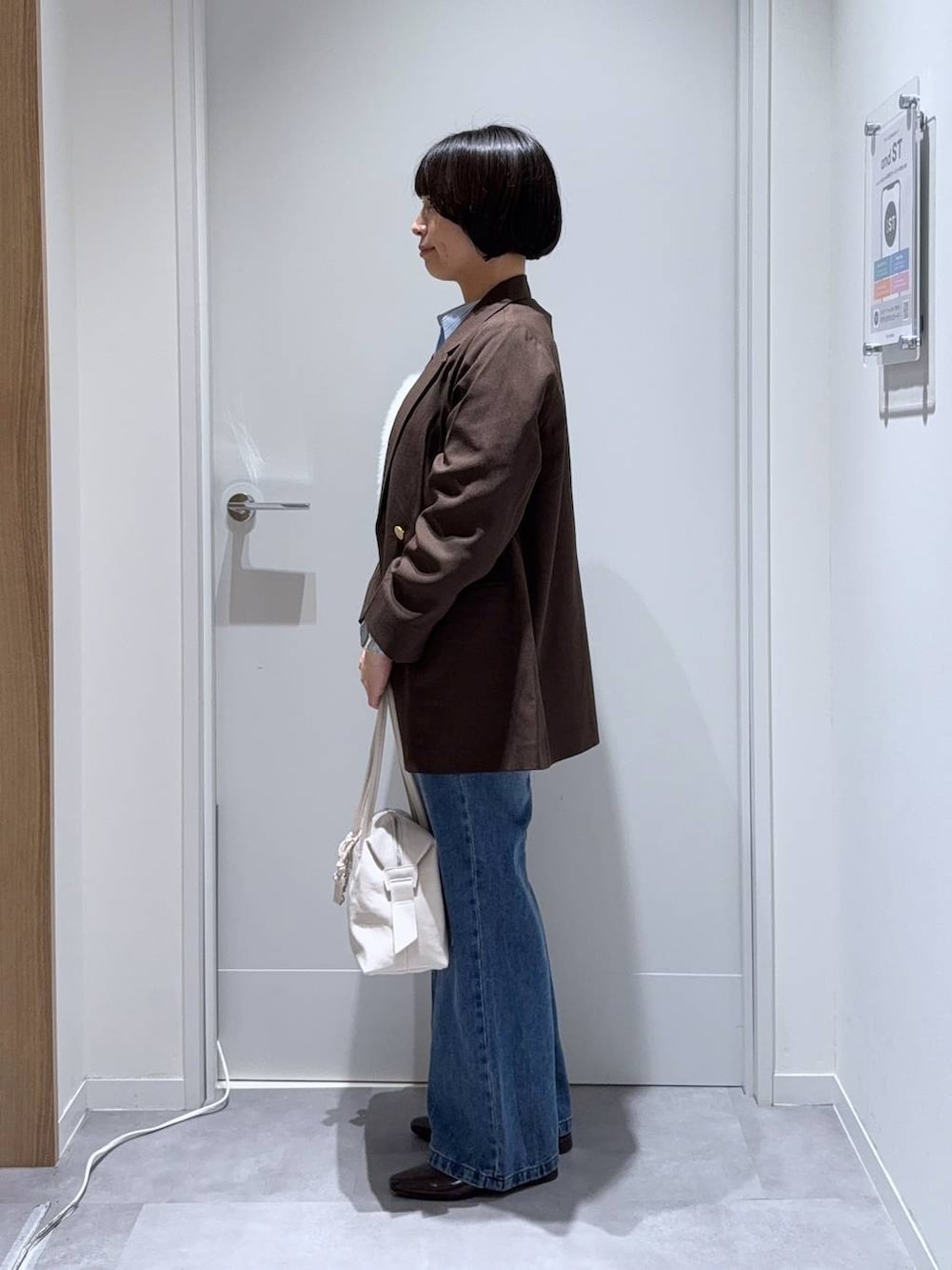 ホワイト系のベスト、レッド系のパンプス、ホワイト系のボストンバッグを着用したレディースの秋コーディネートの2枚目の写真
