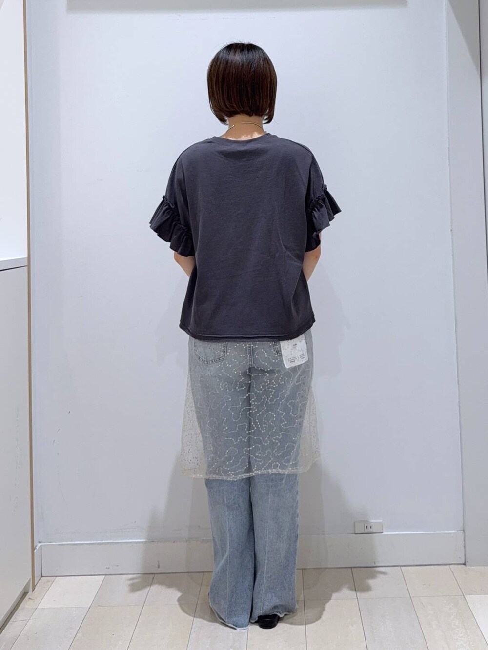 ブルー系のデニムパンツ、グレー系のボストンバッグ、ブラック系のTシャツ/カットソーを着用したレディースの夏コーディネートの3枚目の写真