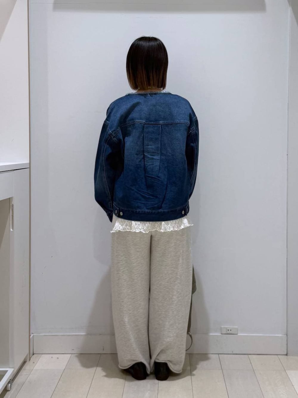 ブラック系のローファー、グリーン系のハンドバッグ、ブルー系のデニムジャケットを着用したレディースの春コーディネートの3枚目の写真