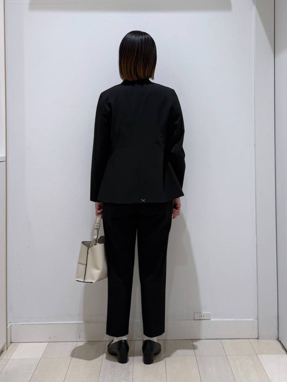 ブラック系のスラックス、パープル系のシャツ/ブラウス、ブラック系のノーカラージャケットを着用したレディースの春コーディネートの3枚目の写真