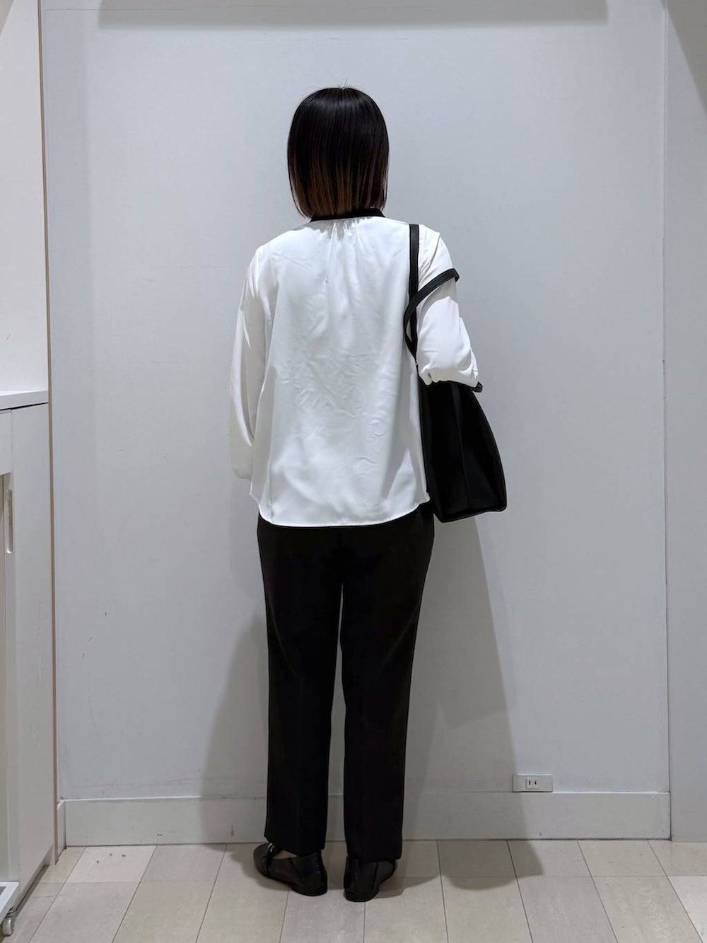 ブラック系のローファー、ホワイト系のシャツ/ブラウス、ブラック系のトートバッグを着用したレディースの春コーディネートの3枚目の写真