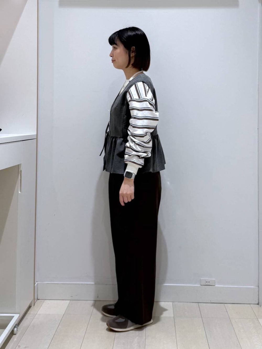 グレー系のスニーカー、ブラウン系のその他パンツ、ブラック系のショルダーバッグを着用したレディースの冬コーディネートの2枚目の写真