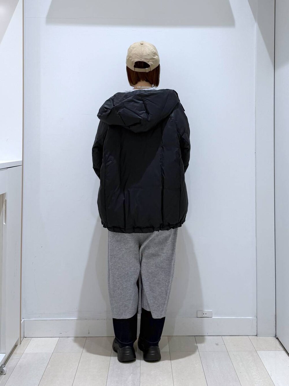 ブラウン系のトートバッグ、ブルー系のダウンジャケット/コート、ブルー系のデニムパンツを着用したレディースの冬コーディネートの3枚目の写真