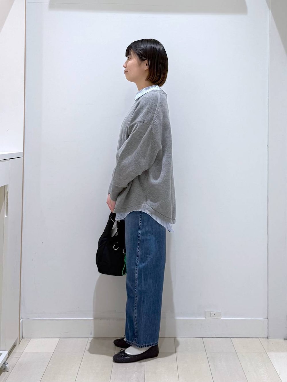 ブラック系のバレエシューズ、ブラック系のトートバッグ、グレー系のニット/セーターを着用したレディースの冬コーディネートの2枚目の写真