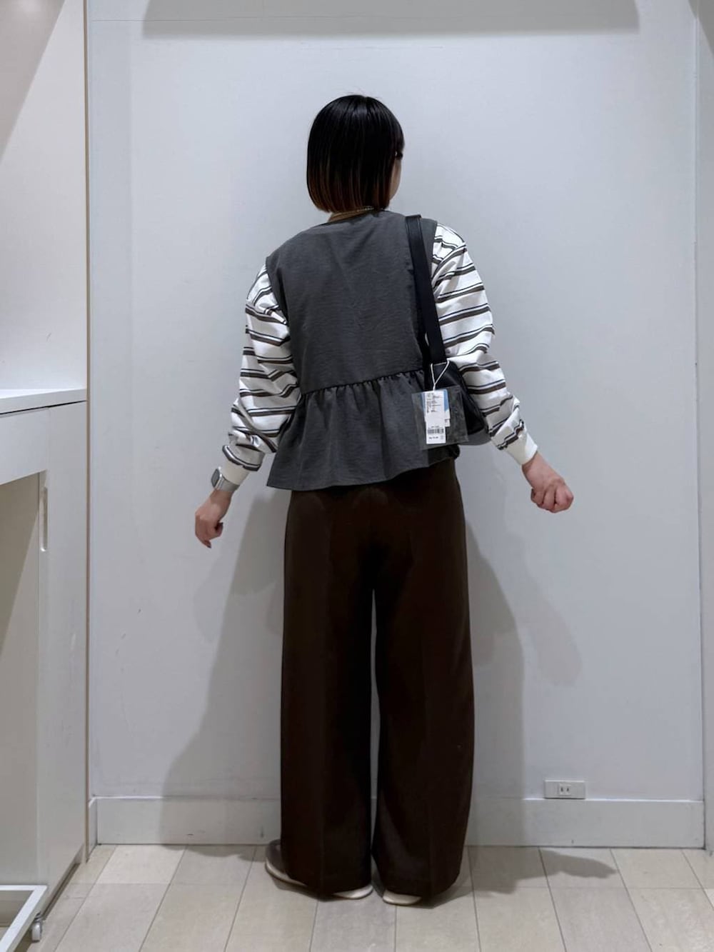 グレー系のスニーカー、ブラウン系のその他パンツ、ブラック系のショルダーバッグを着用したレディースの冬コーディネートの3枚目の写真