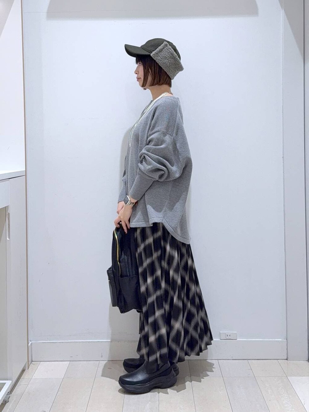 ブラック系のバックパック/リュック、グレー系のニット/セーター、ブラック系のブーツを着用したレディースの冬コーディネートの2枚目の写真