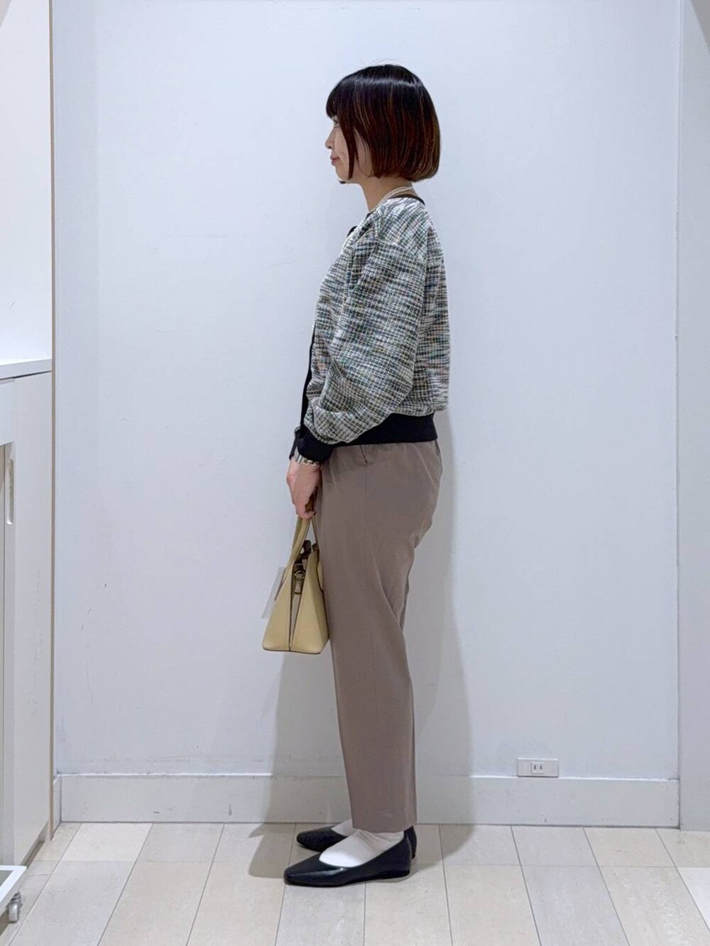 ブラック系のパンプス、ベージュ系のショルダーバッグ、ブラウン系のその他パンツを着用したレディースの秋コーディネートの2枚目の写真