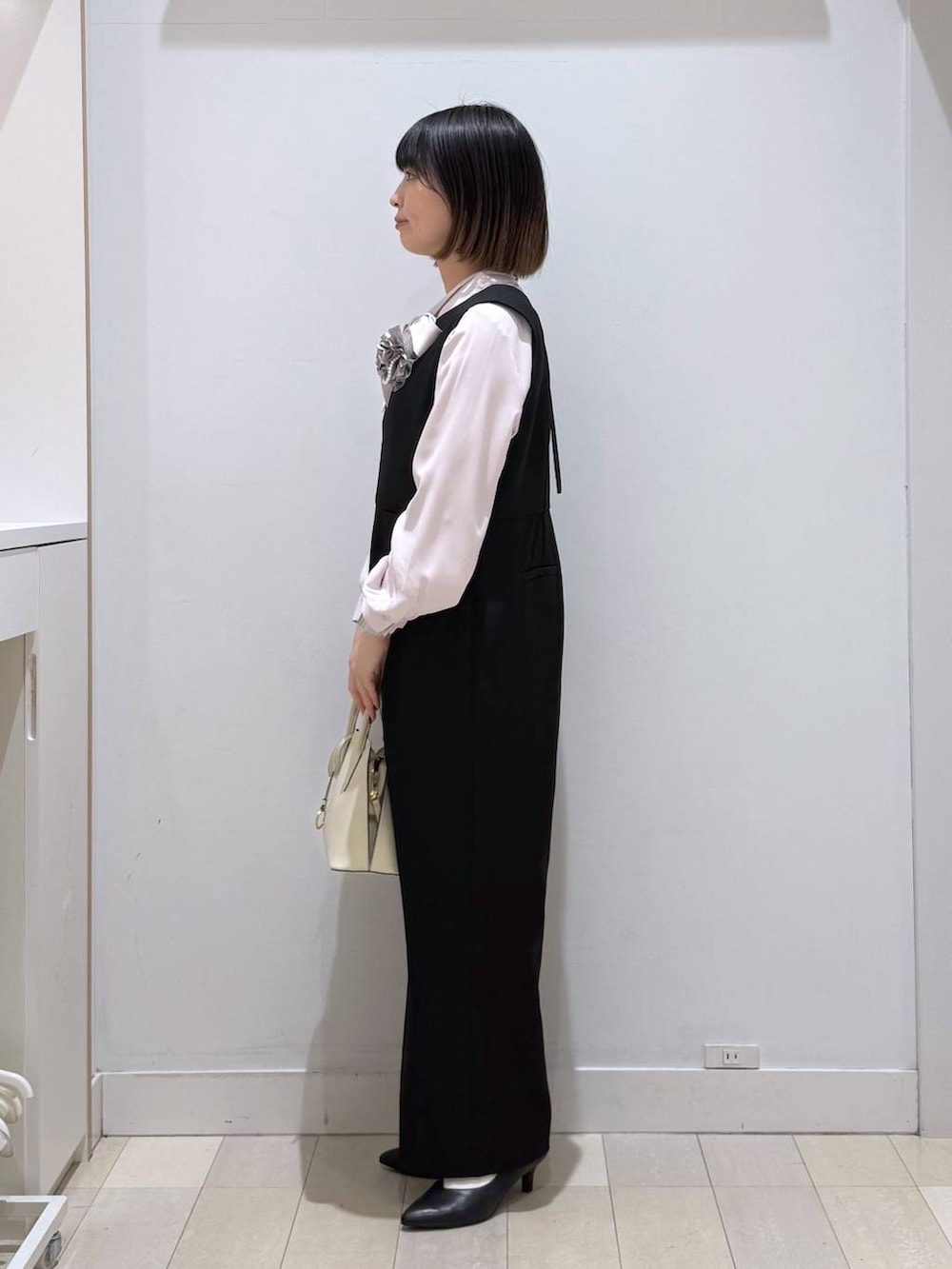 ホワイト系のショルダーバッグ、ピンク系のシャツ/ブラウス、ブラック系のパンプスを着用したレディースの春コーディネートの2枚目の写真