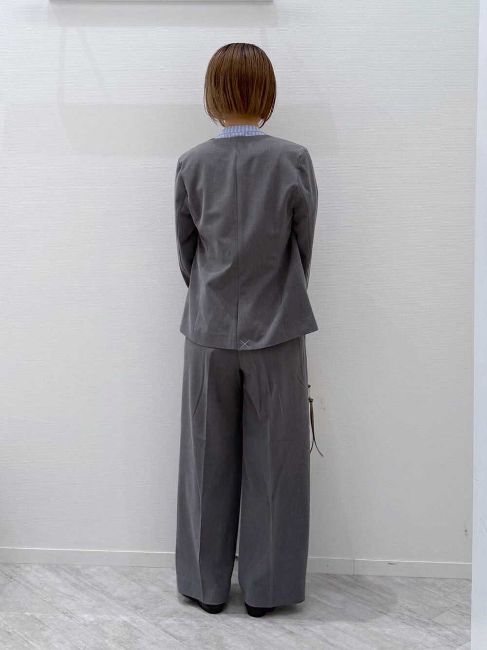 ブラック系のパンプス、ベージュ系のショルダーバッグ、ブルー系のシャツ/ブラウスを着用したレディースの春コーディネートの3枚目の写真