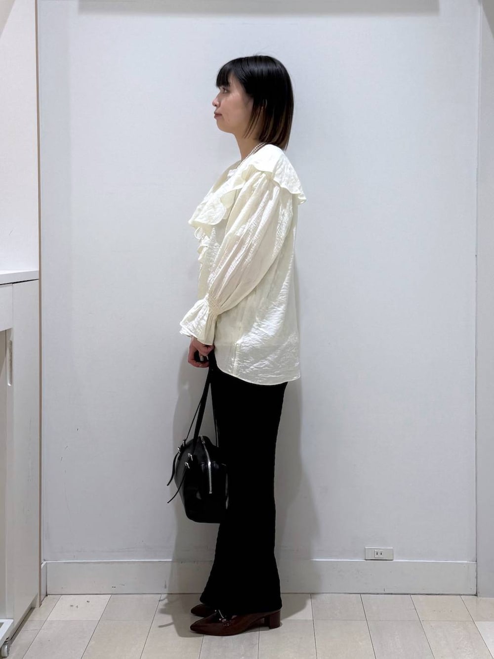 ブラウン系のローファー、ブラック系のショルダーバッグ、ホワイト系のTシャツ/カットソーを着用したレディースの春コーディネートの2枚目の写真