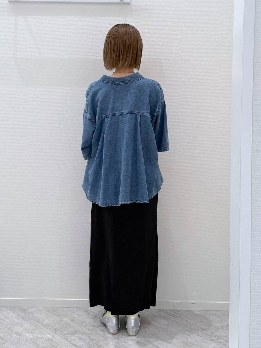 グレー系のボストンバッグ、ブルー系のシャツ/ブラウス、ブラック系のスカートを着用したレディースの春コーディネートの3枚目の写真