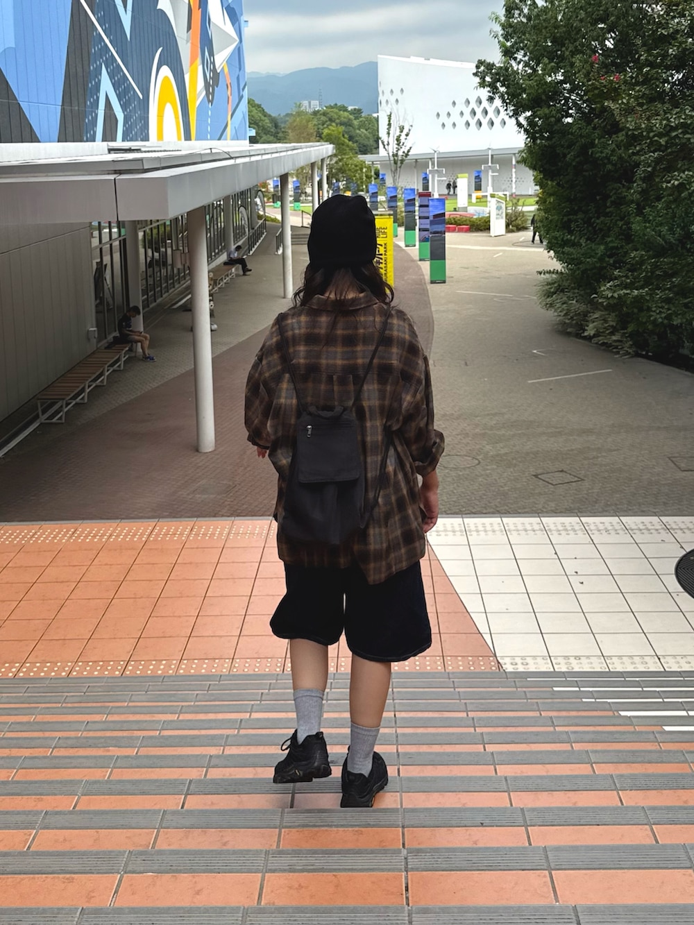 グレー系のシャツ/ブラウス、ブルー系のデニムパンツ、ブラック系のバックパック/リュックを着用したレディースの秋コーディネートの2枚目の写真