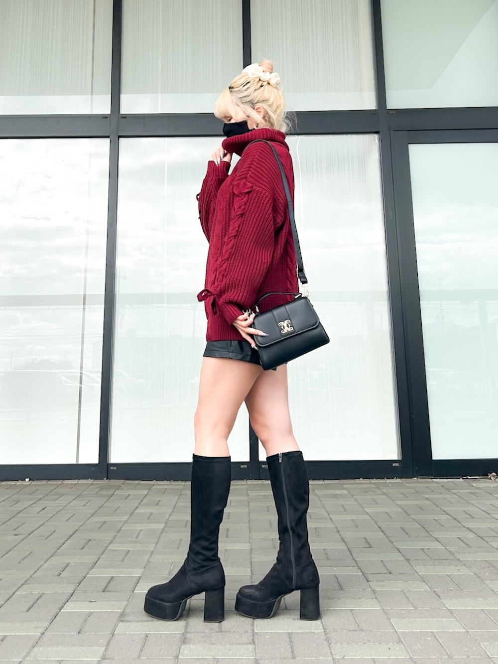 レッド系のチュニック、ブラック系のその他パンツ、ブラック系のハンドバッグを着用したレディースの冬コーディネートの4枚目の写真