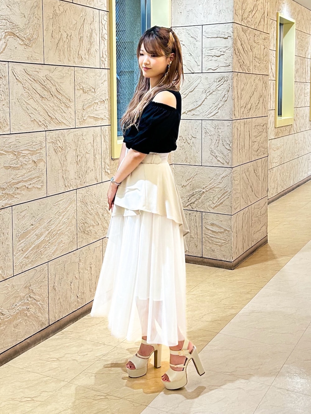 ベージュ系のスカート、ブラック系のニット/セーターを着用したレディースの夏コーディネートの4枚目の写真