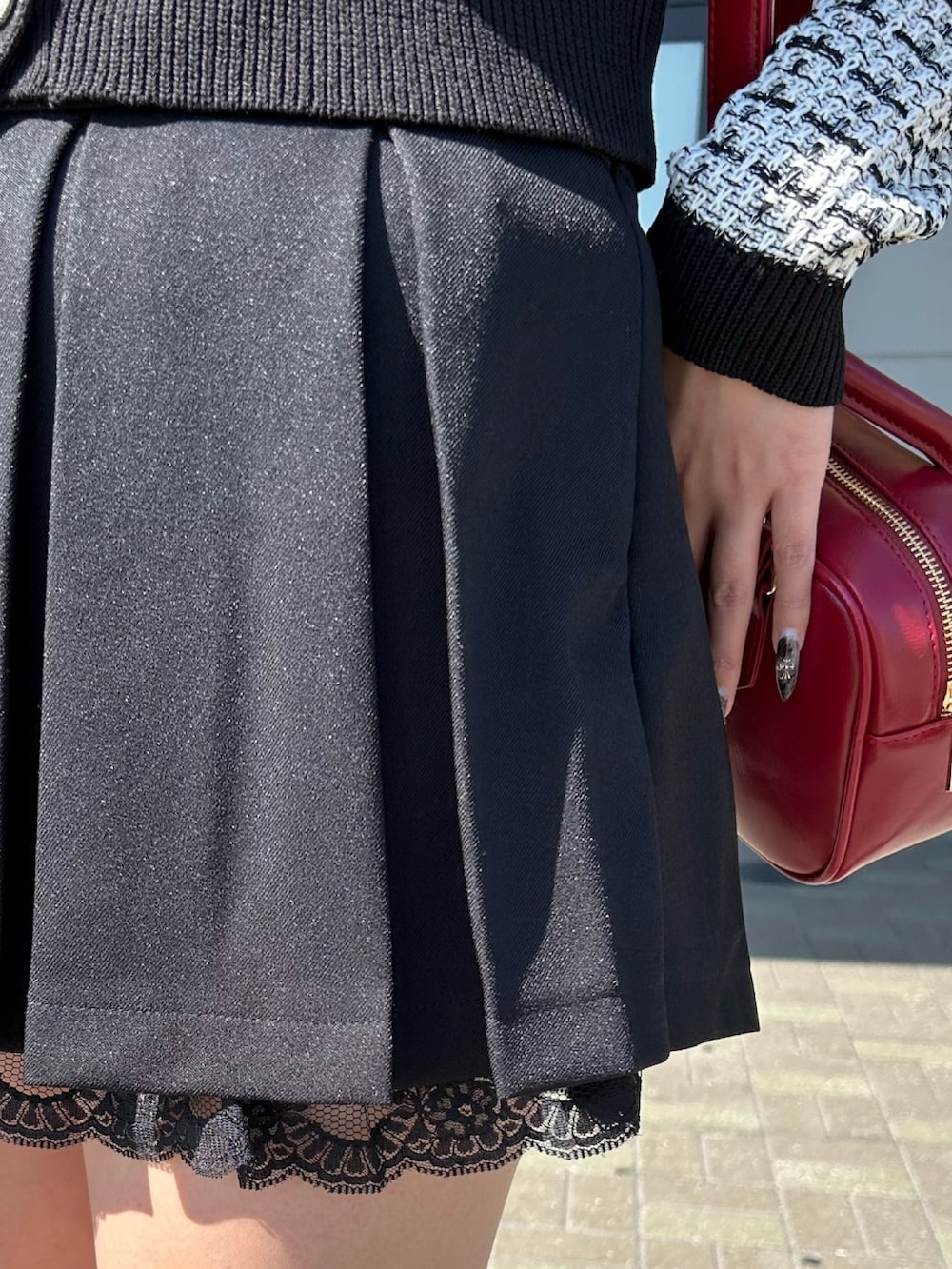 ホワイト系のカーディガン/ボレロ、ブラック系のスカート、レッド系のボストンバッグを着用したレディースの春コーディネートの5枚目の写真