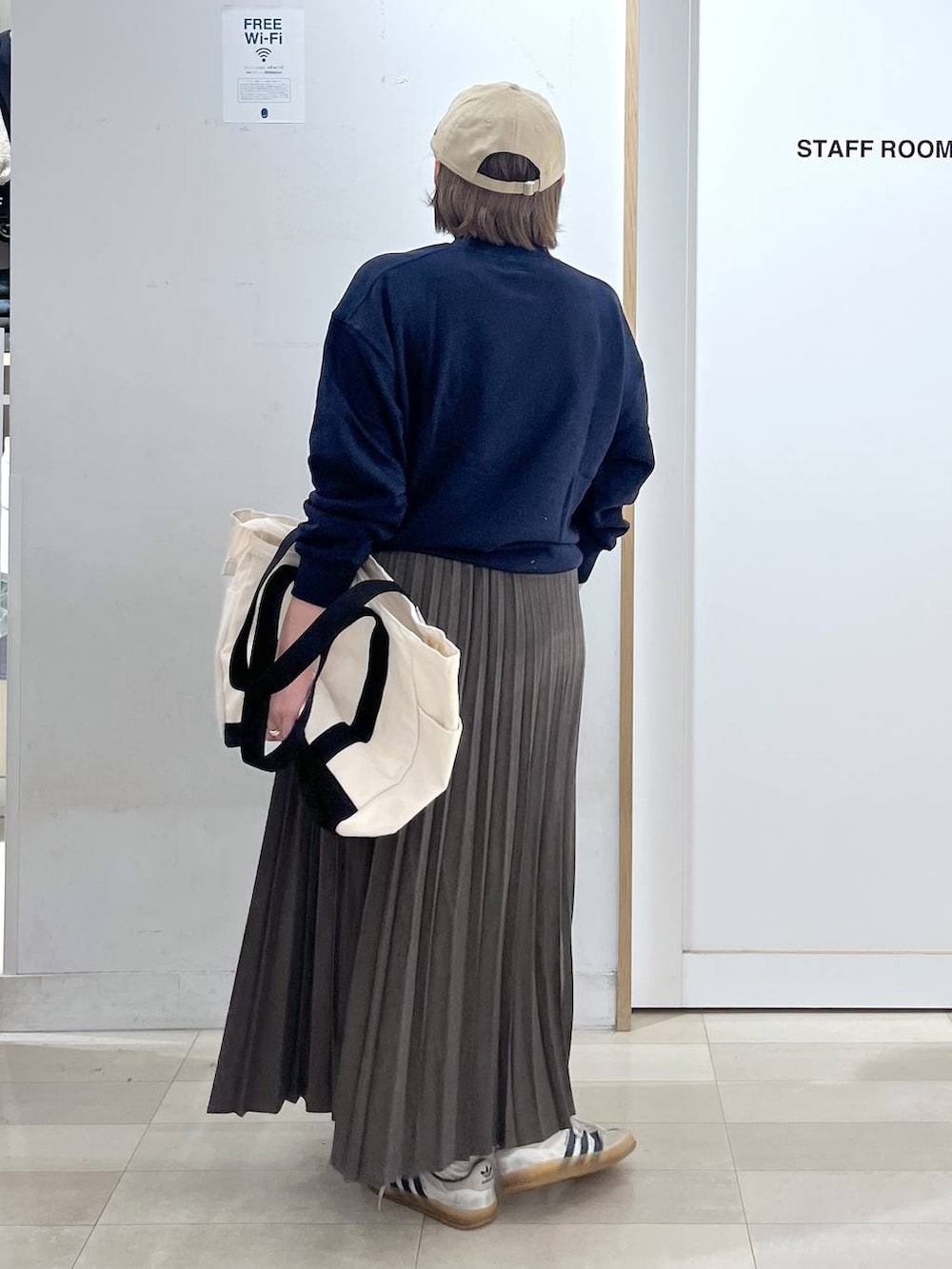 ホワイト系のトートバッグ、ブルー系のスウェット、ベージュ系のスカートを着用したレディースの秋コーディネートの3枚目の写真