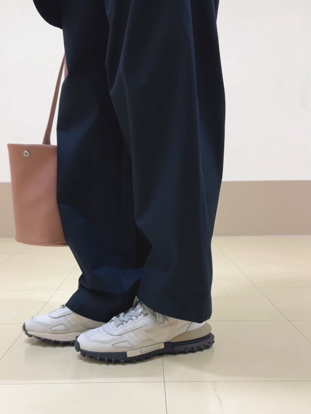 ブルー系のチノパンツ、グレー系のポロシャツ、ブルー系のテーラードジャケットを着用したレディースの秋コーディネートの5枚目の写真