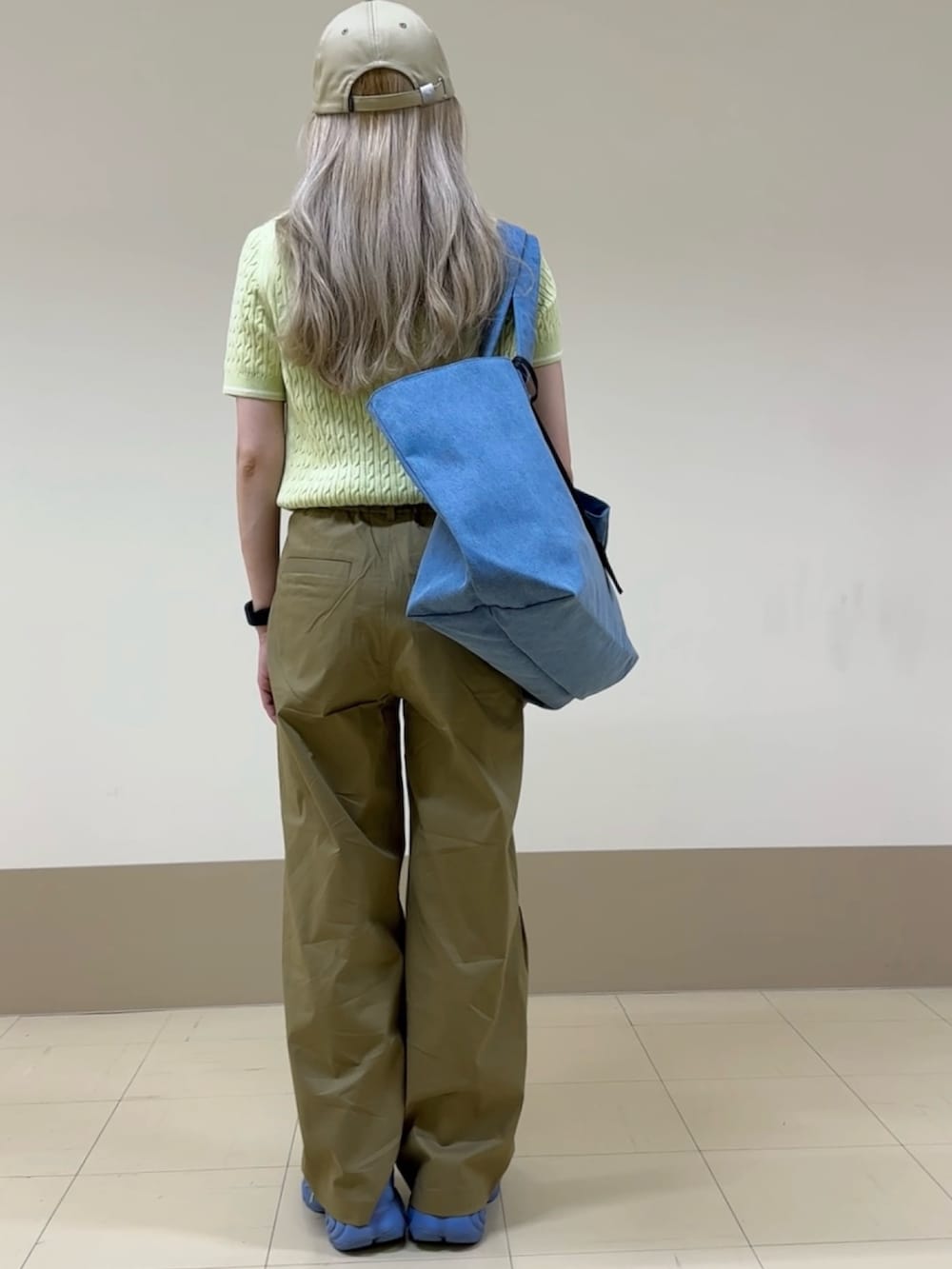 ベージュ系のチノパンツ、グリーン系のスニーカー、ブルー系のトートバッグを着用したレディースの夏コーディネートの2枚目の写真
