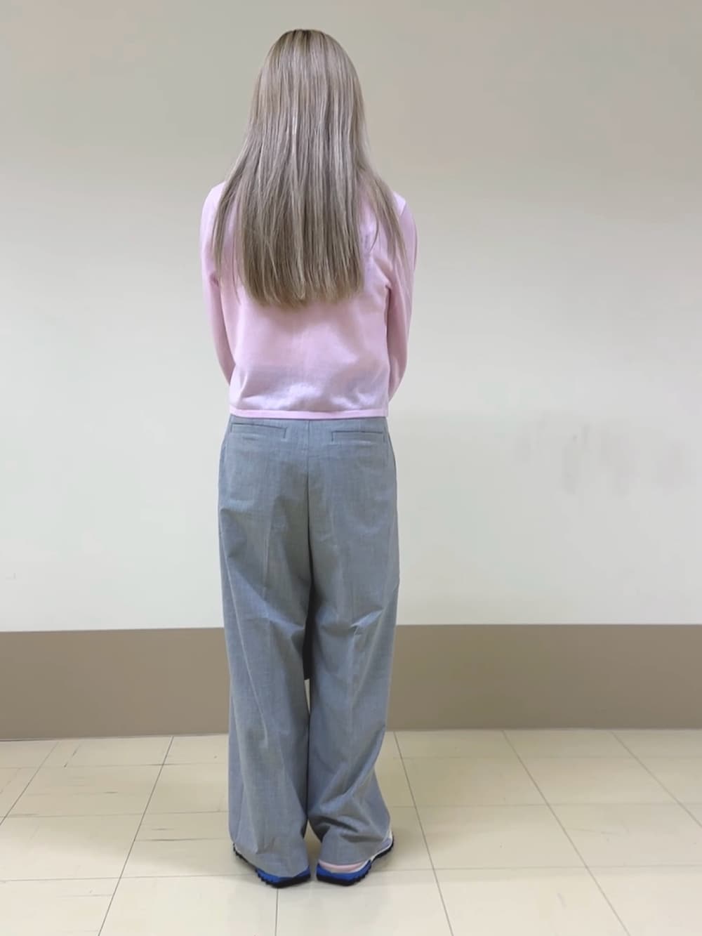 ピンク系のカーディガン/ボレロ、ホワイト系のTシャツ/カットソー、グレー系のスラックスを着用したレディースの春コーディネートの2枚目の写真