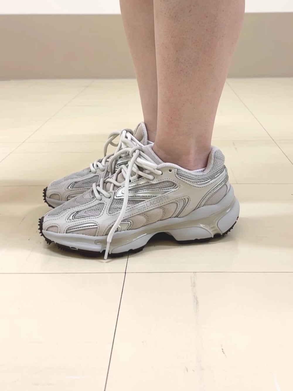 ホワイト系のデニムパンツ、ベージュ系のボストンバッグ、ホワイト系のカーディガン/ボレロを着用したレディースの夏コーディネートの5枚目の写真