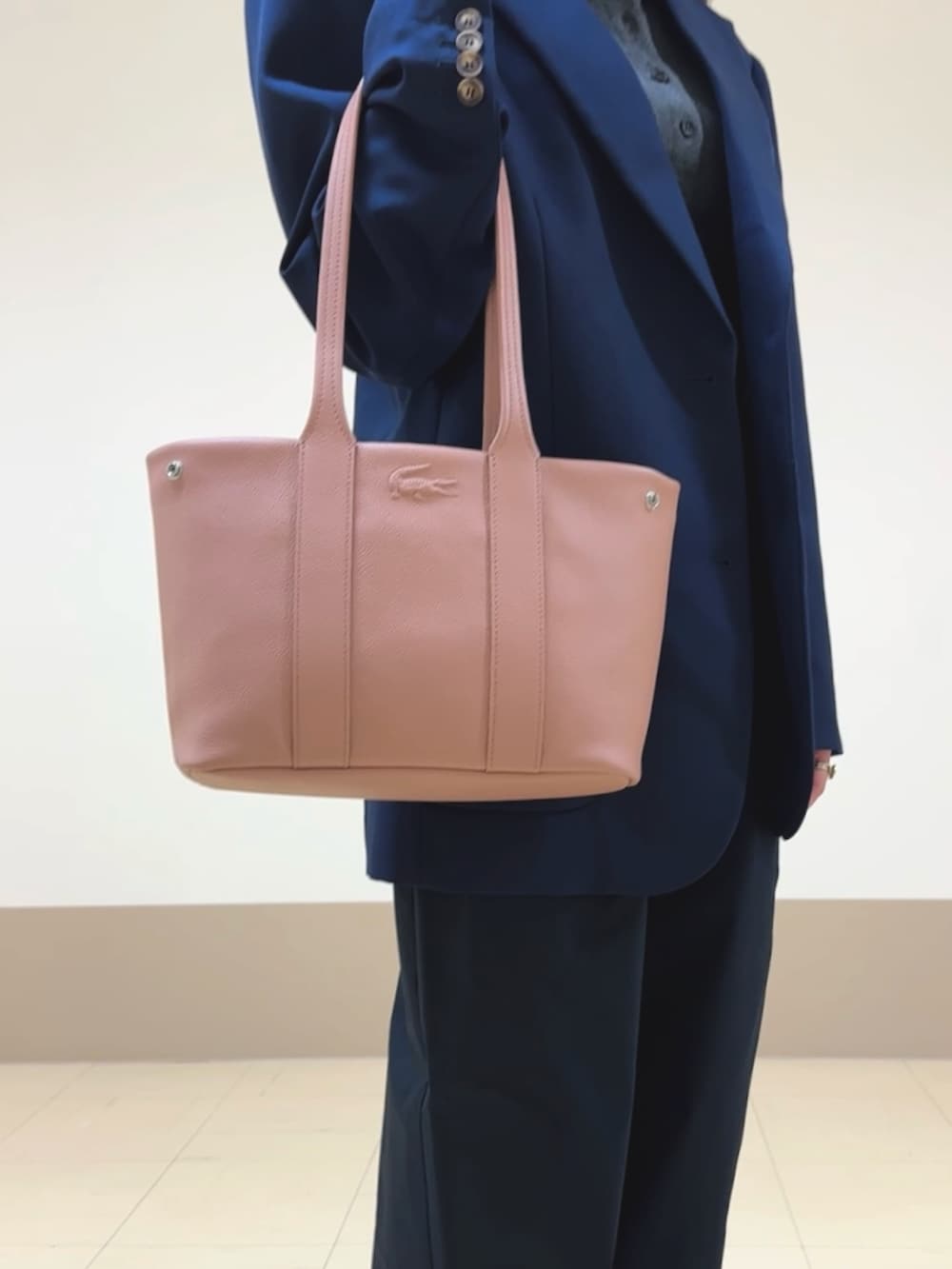 ブルー系のチノパンツ、グレー系のポロシャツ、ブルー系のテーラードジャケットを着用したレディースの秋コーディネートの4枚目の写真