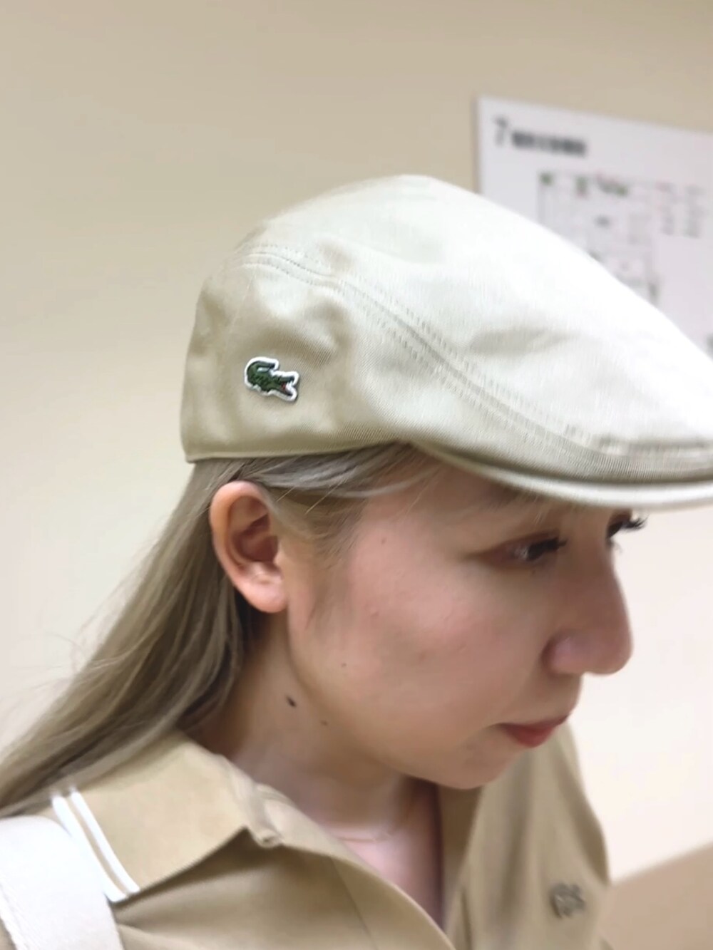 ブラウン系のスカート、ベージュ系のポロシャツ、ホワイト系のスニーカーを着用したレディースの夏コーディネートの5枚目の写真