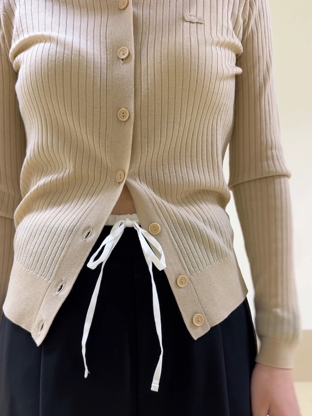 ブラック系のハンドバッグ、ブラック系のパンツ、ピンク系のスニーカーを着用したレディースの冬コーディネートの4枚目の写真