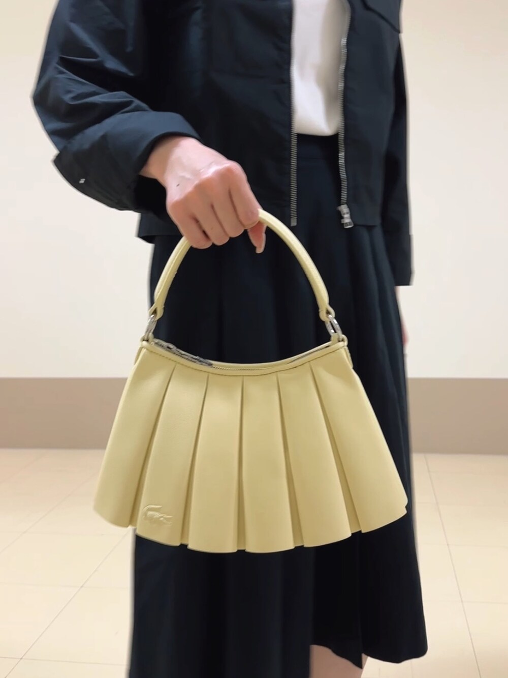 ブラック系のシャツ/ブラウス、イエロー系のハンドバッグ、シルバー系のスニーカーを着用したレディースの秋コーディネートの3枚目の写真