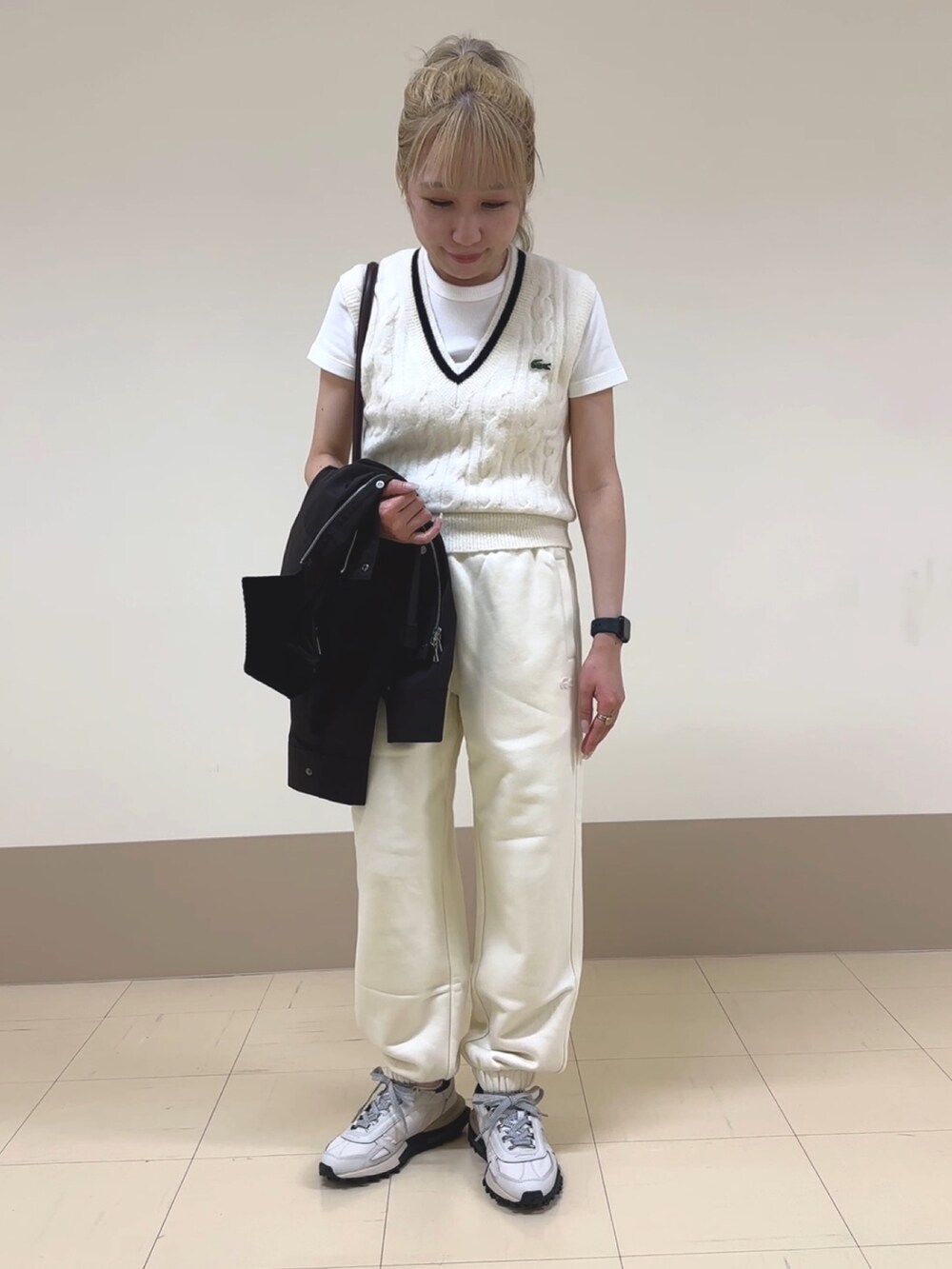 ホワイト系のスウェットパンツ、ベージュ系のスニーカー、ブラウン系のショルダーバッグを着用したレディースの秋コーディネートの4枚目の写真