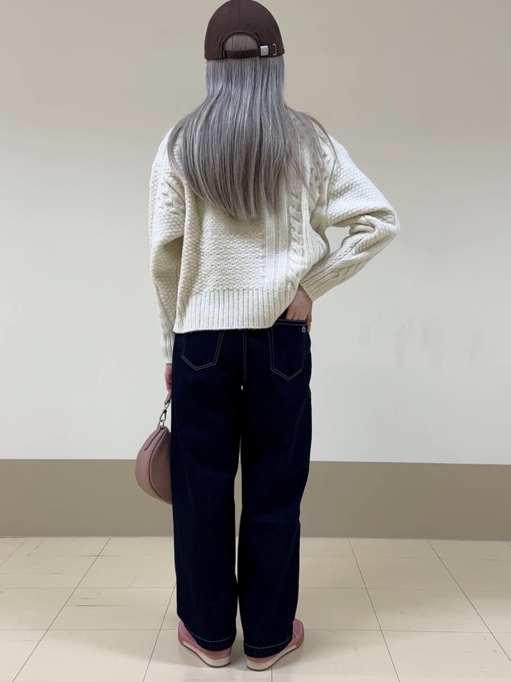 ホワイト系のニット/セーター、ブルー系のデニムパンツ、ピンク系のハンドバッグを着用したレディースの冬コーディネートの2枚目の写真