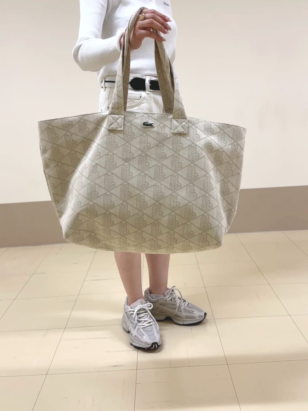 ホワイト系のデニムパンツ、ベージュ系のボストンバッグ、ホワイト系のカーディガン/ボレロを着用したレディースの夏コーディネートの4枚目の写真